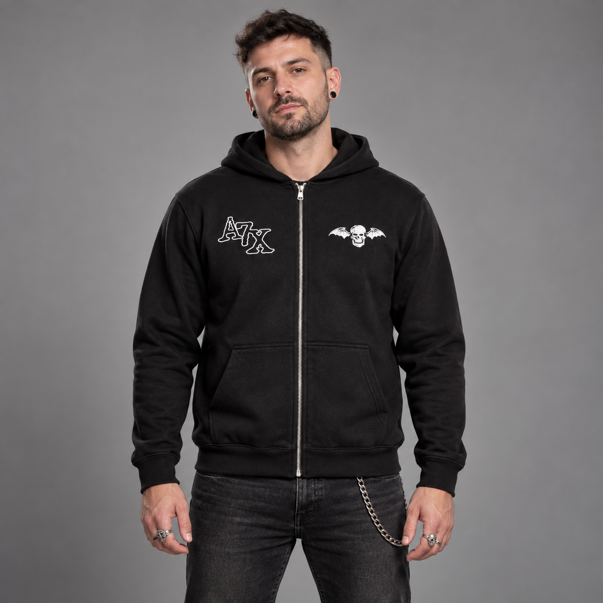 Studio front view of a man wearing the black Avenged Sevenfold Dead Head zip-up hoodie with A7X and deathbat chest graphics.