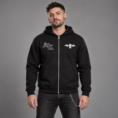 Studio front view of a man wearing the black Avenged Sevenfold Dead Head zip-up hoodie with A7X and deathbat chest graphics.