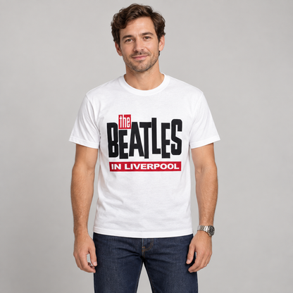 Man wearing the white The Beatles in Liverpool T-shirt with black and red lettering in a studio.