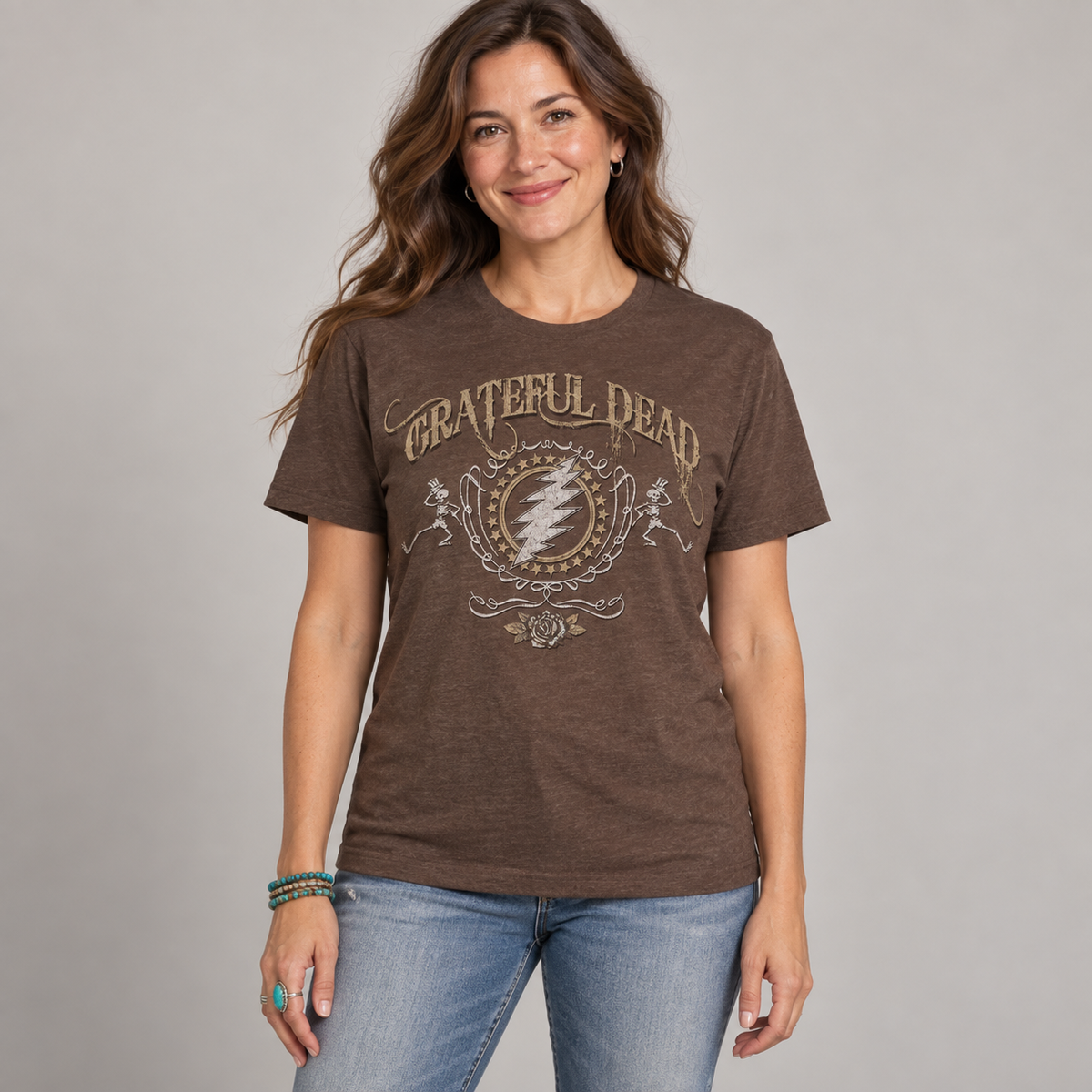 Studio photo of a woman wearing the brown Grateful Dead Bolt T-shirt, showing vintage lightning bolt, skeleton and rose artwork.