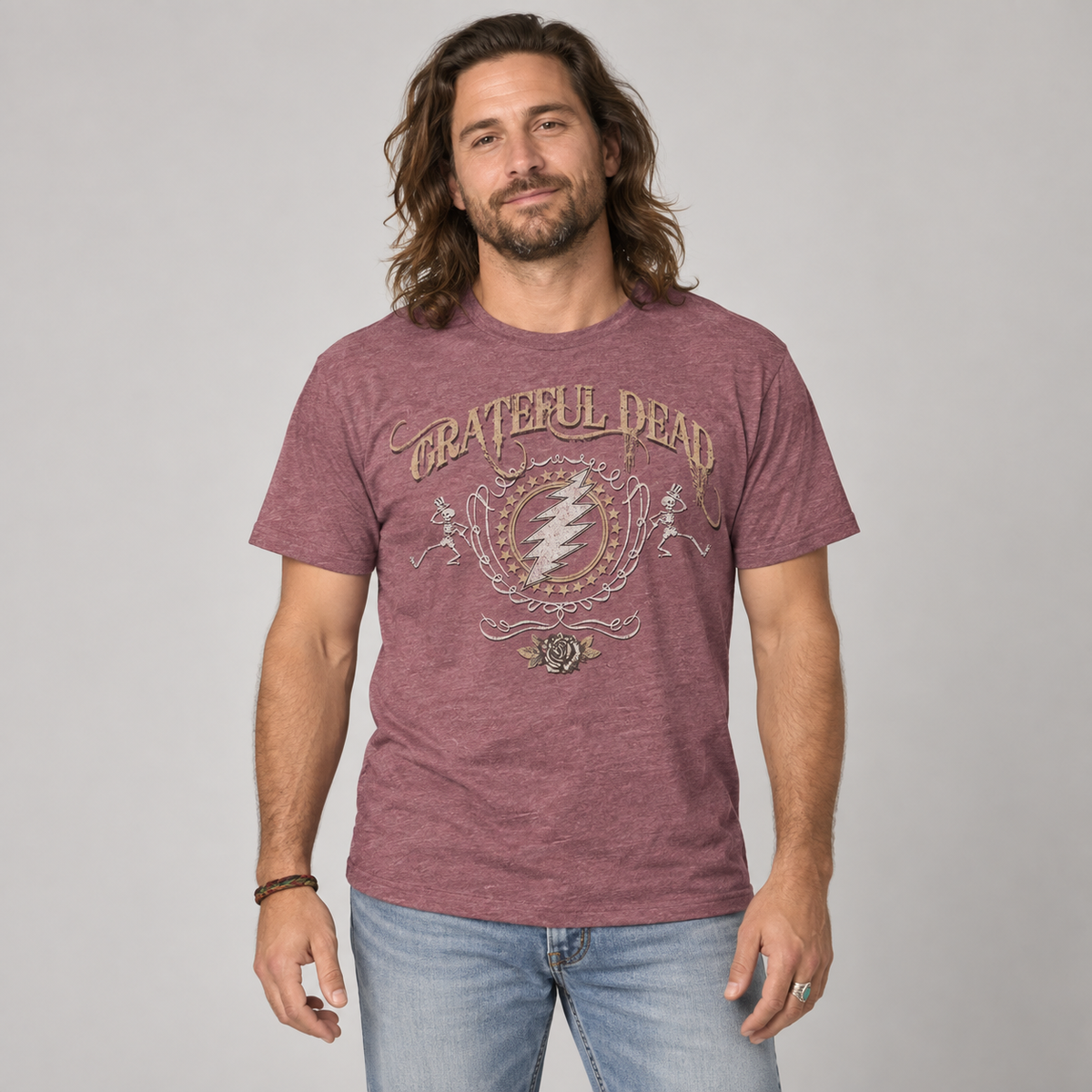 Studio photo of a man wearing the heather cardinal Grateful Dead Bolt T-shirt with vintage lightning bolt, skeleton and rose artwork.