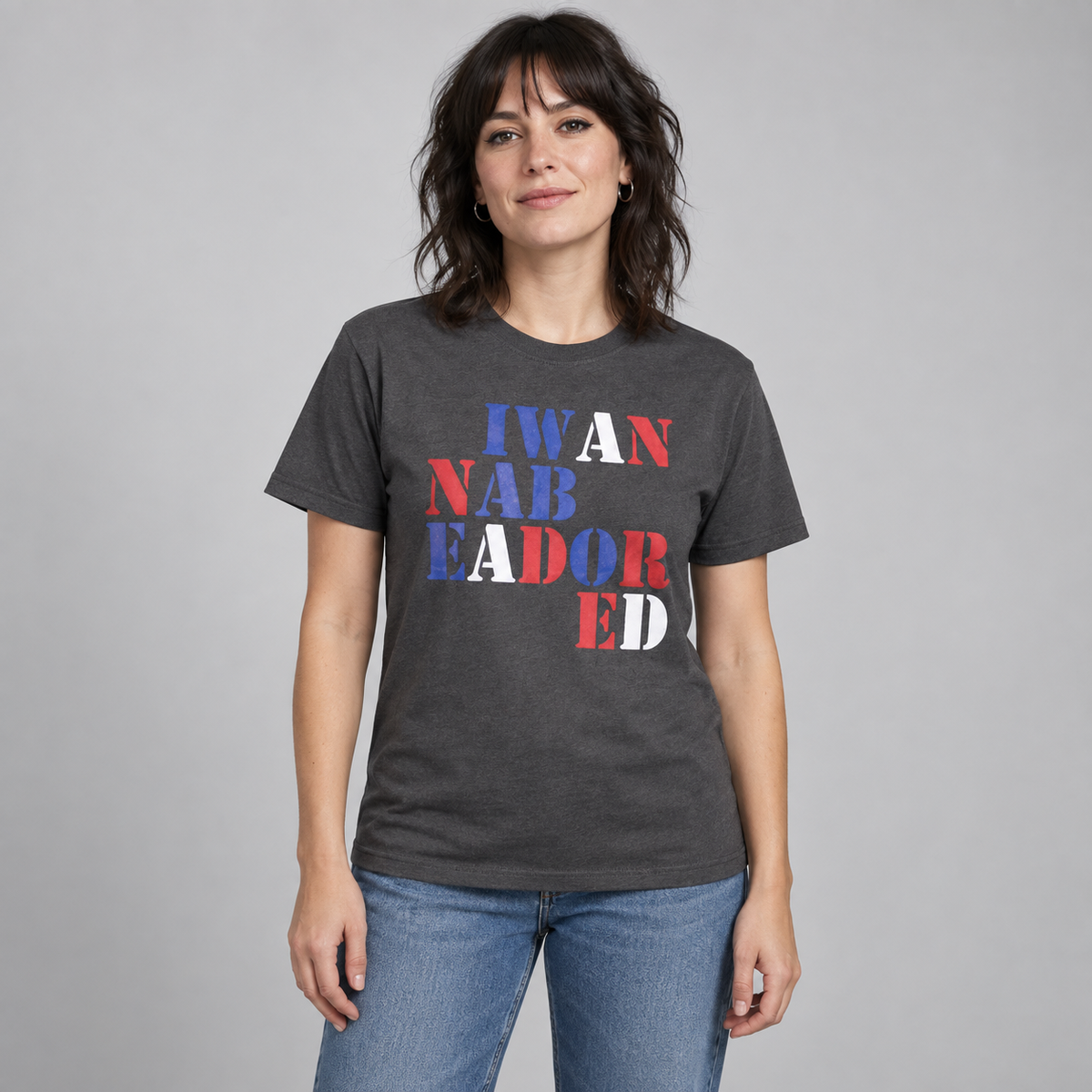 Woman wearing the charcoal Stone Roses Adored T-shirt with red, white and blue stencil lettering in a studio.