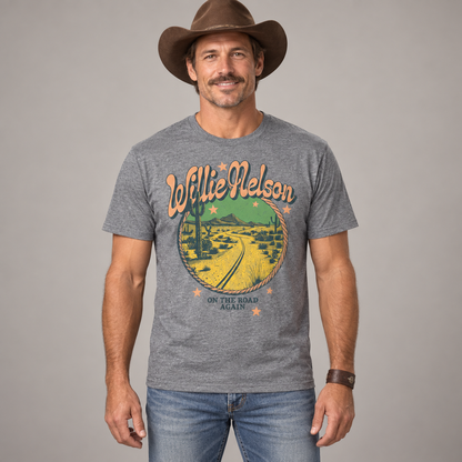 Man in country styling wearing the heather-grey Willie Nelson On the Road Again T-shirt in a studio.